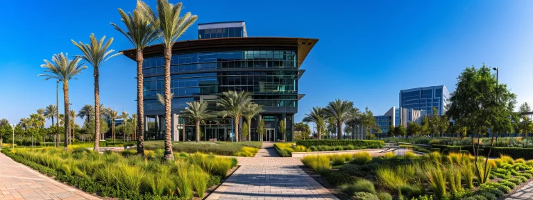 a modern office building towering against a clear blue sky, surrounded by vibrant green landscaping, symbolizing success in commercial real estate.